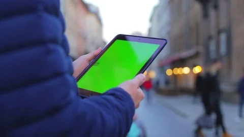 Man hand touching tablet computer surface touch screen on street. Green screen Stock Footage 76562561