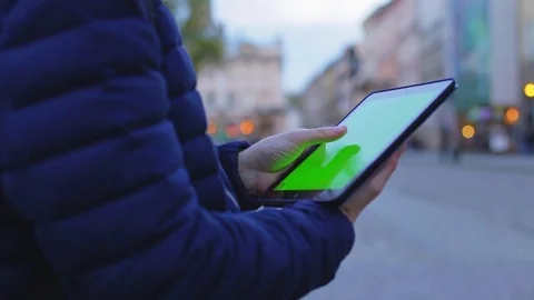 Man hand touching tablet computer surface green touchscreen on street in Europe Stock Footage 76563194