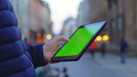 Man hand touching tablet computer surface touchscreen on street. Green screen Stock Footage 76563397