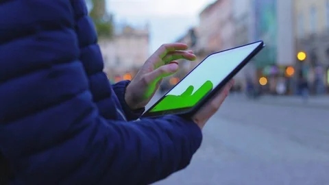 Man hand touching tablet computer surface touchscreen in town. Green screen Stock Footage 76583799
