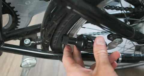 Man hand turns off the bicycle dynamo. Removes dynamo from bike tire. Close-up 動画素材 197479844