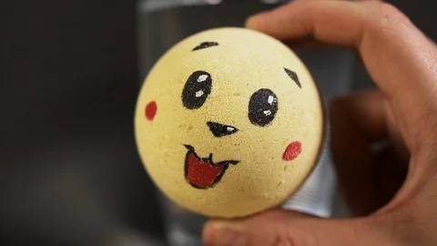 Man hand twist ball bath salt with interesting face for experimenting water Stock Footage 114485626