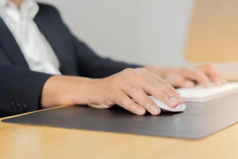 Man hand typing on computer keyboard and holding computer mouse on wooden d.. Stock Photos