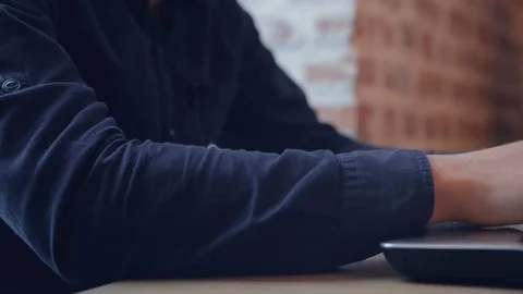 Man hand typing on laptop computer in a dark shirt Stockbeeldmateriaal 93840671