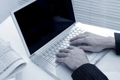 Man hand typing on laptop computer in office Stock Photos