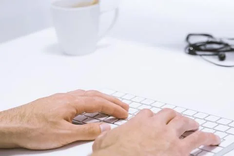 Man hand typing working on wireless keyboard on white work place Stock Photos