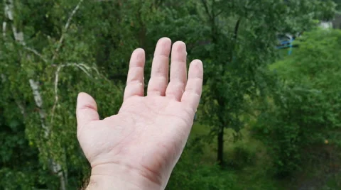 Man hand under the rain collecting raindrops Stock Footage 64570929