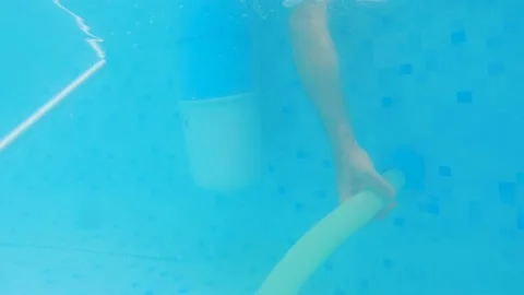 Man hand under water using plastic hose to connect filter pump and pool skinner Stock Footage 202126293