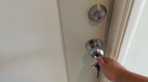 Man hand use a key for lock or unlock wooden door Stock Photos