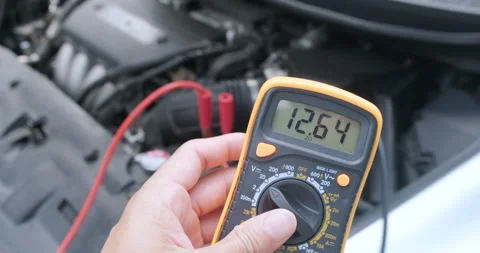 Man hand uses multimeter voltmeter to check voltage level in car battery Stock Footage 146052140