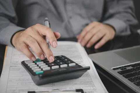 Man hand using calculator for financial analysis, tax calculation. Business.. Foto stock