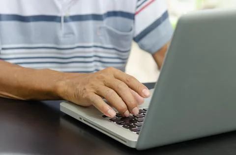 Man hand using computer laptop on table at home Stock Photos