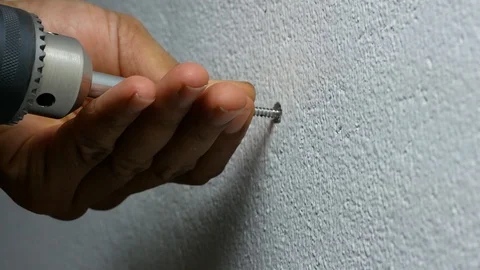 Man hand using electric screwdriver to tighten the screw into plastic plug , Vidéo 89729884