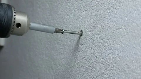 Man hand using electric screwdriver to tighten the screw into plastic plug , Stock Footage 89729918