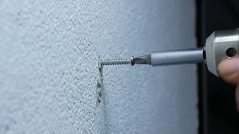 Man hand using electric screwdriver to tighten the screw into plastic plug , Stock Footage 89730961