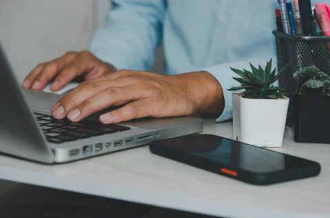 Man hand using laptop computer keyboard Stock Photos