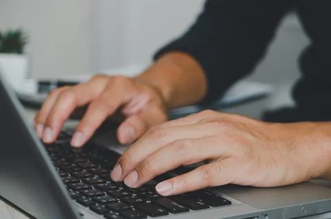 Man hand using laptop computer keyboard Stock Photos