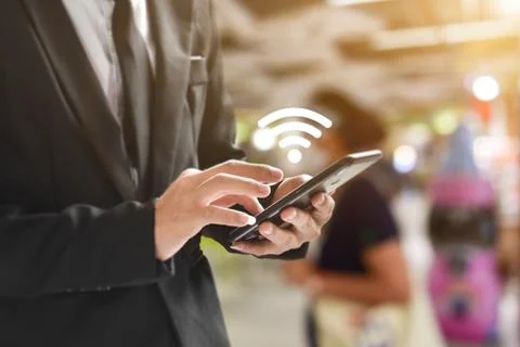 Man hand using mobile smartphone with wifi icon. Idea for business communicat Stock Photos