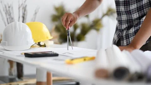 Man hand is using a roundabout to write on a house plan, Architect writing .. Foto stock