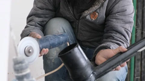 Man hand using a saw to cut a black water pipe Stock Footage 238534300