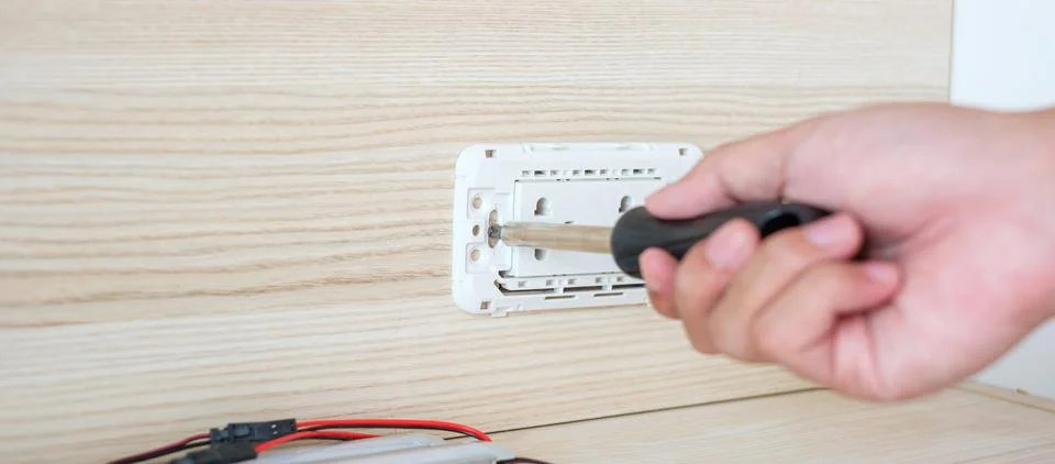 Man hand using screwdriver installing Wire cables for socket plug. Renovati.. Stock Photos