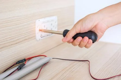 Man hand using screwdriver installing Wire cables for socket plug. Renovati.. Stock Photos