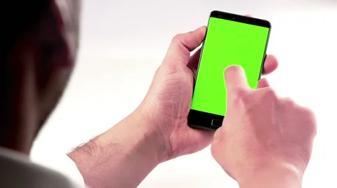 Man hand using a smart phone with chroma key on white background behind view Video stock 61364150