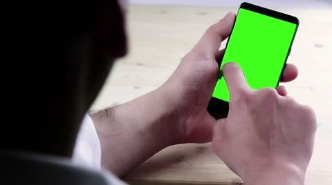 Man hand using a smart phone with chroma key on wood table Video stock 62285362