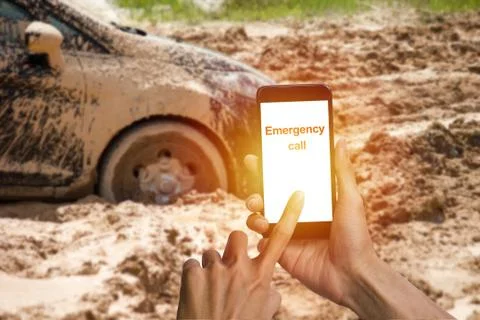 Man hand using smartphone calling emergency for help car tire stuck in the mu Stock Photos