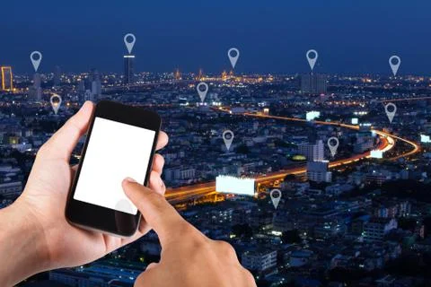 Man hand using smartphone searching loaction  on map pin on top view city sca Stock Photos
