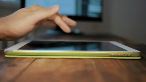 Man hand using tablet computer pc commuter in background The monitor in the Stock Footage 83159982