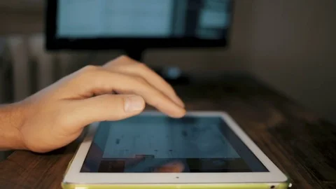 Man hand using tablet computer pc commuter in background The monitor in the Stock Footage 83163242