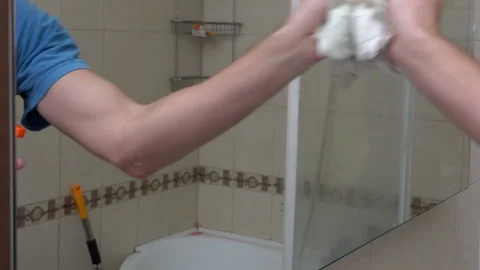 Man Hand Wipes the Mirror With a Rag in the Bathroom. Stock Footage 167657148
