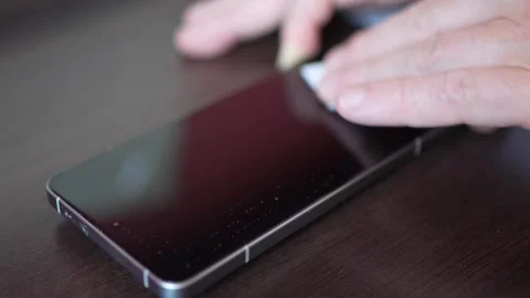 Man hand wiping smartphone screen with cleaning cloth before installing pro.. Stock-Footage 337895211