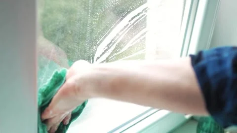 Man hand wiping window pane with a rag to clean soap stains at home Vídeo Stock 340159613