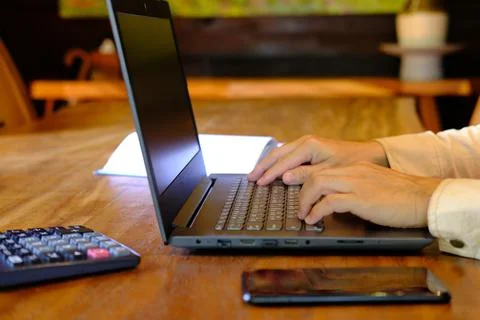Man hand working on laptop computer on table and home quarantine new normal Stock Photos