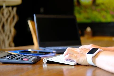 Man hand working on laptop computer on table and home quarantine new normal Stock Photos