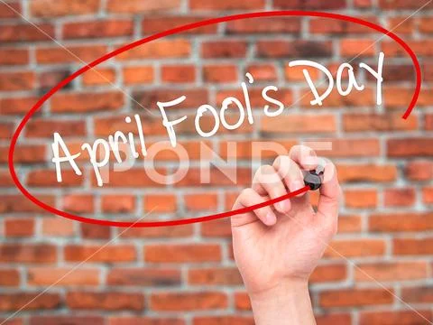 Man Hand writing April Fool's Day with black marker on visual sc Stock Photos