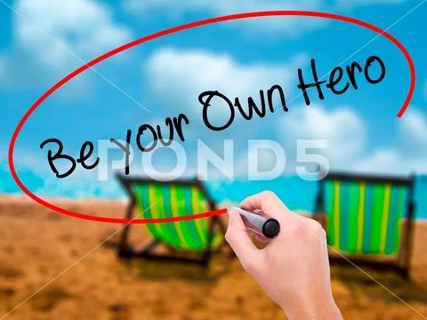Man Hand writing Be your Own Hero with black marker on visual Stock Photos