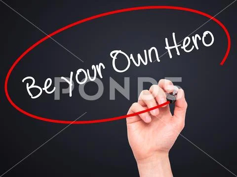 Man Hand writing Be your Own Hero with black marker on visual Stock Photos
