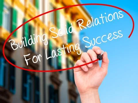 Man Hand writing Building Solid Relations For Lasting Success wi Fotos de archivo