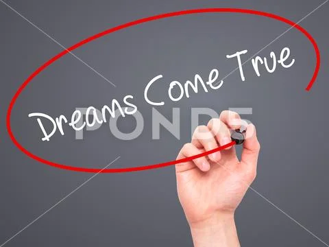 Man Hand writing Dreams Come True with black marker on visual sc Stock Photos