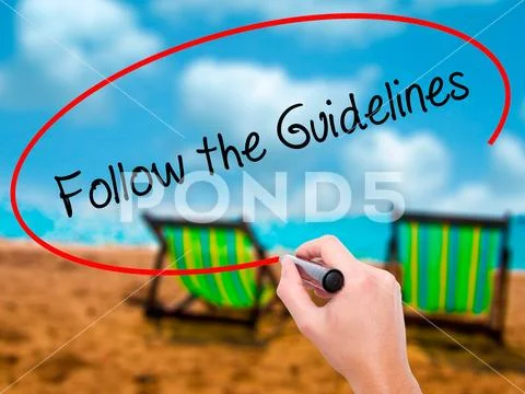 Man Hand writing Follow the Guidelines with black marker on vis Stock Photos