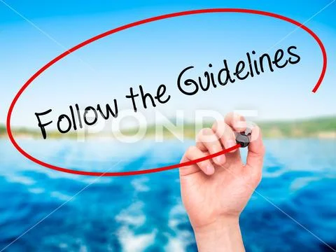 Man Hand writing Follow the Guidelines with black marker on vis Stock Photos