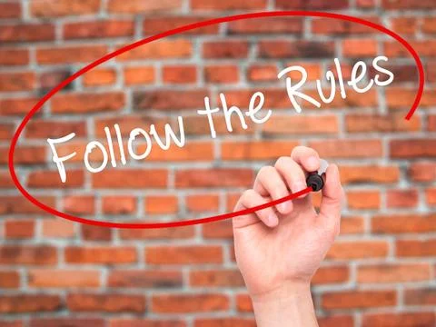 Man Hand writing Follow the Rules  with black marker on visual screen Stock Photos
