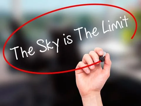 Man Hand writing The Sky is The Limit  with black marker on visual screen Stock Photos