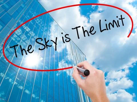 Man Hand writing The Sky is The Limit  with black marker on visual screen Stock Photos