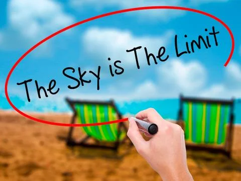 Man Hand writing The Sky is The Limit  with black marker on visu Stock Photos