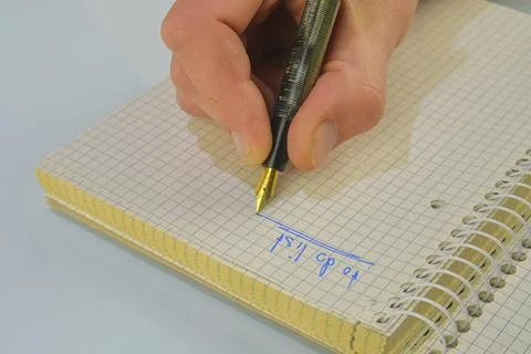 Man hand writing text - to do list - in notebook. Fountain pen, spiral notebook Фото