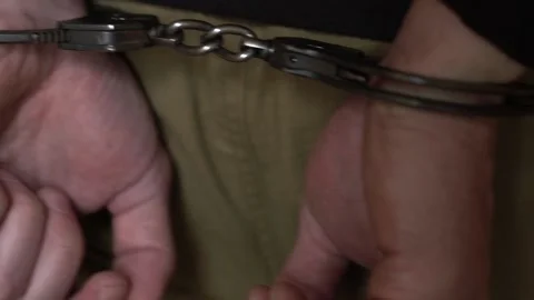 Man in handcuffs. Prisoner or arrested man with handcuffs is walking. Stock Footage 136693141